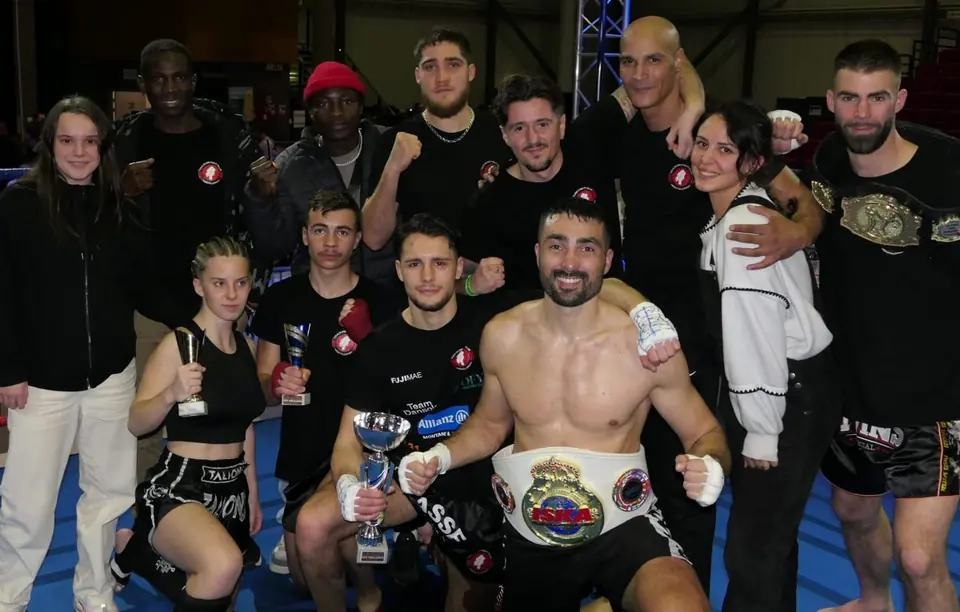 Des combattants du club réunis avec leurs trophées et une ceinture